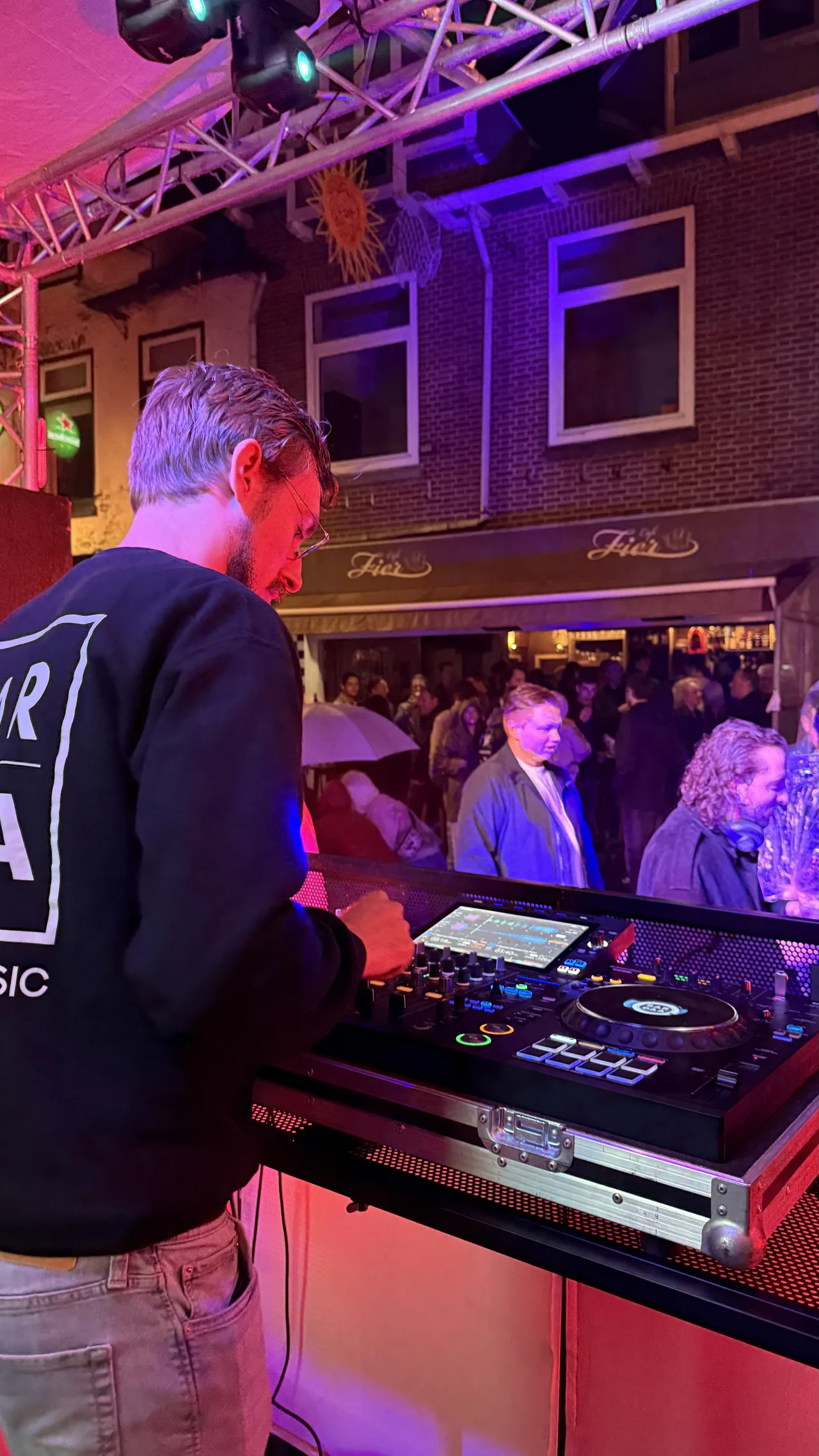 Uitzicht vanuit de DJ-booth richting het publiek in paars licht